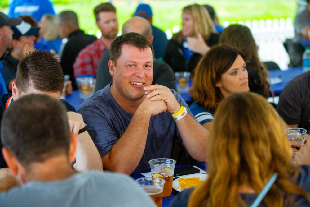 Man smiling in seat surrounded by others at Comerica Park event